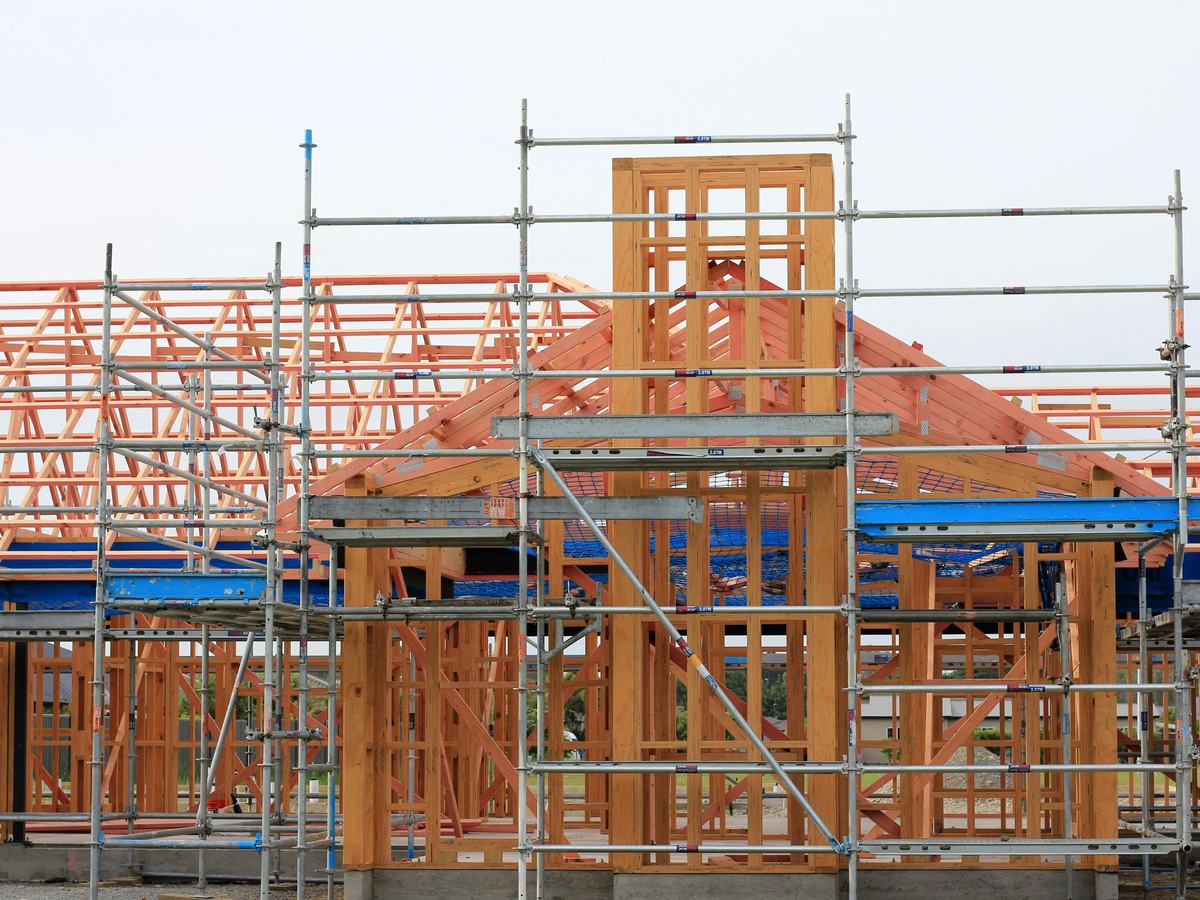 Timber house frame and roof trusses under scaffolding on a residential build