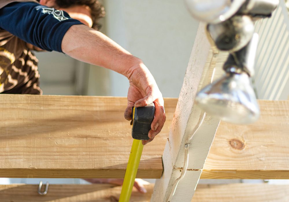 Tape measure held across timber bearers and joists